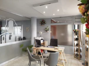 Bureau d'accueil funéraire moderne avec ordinateur et décoration florale.